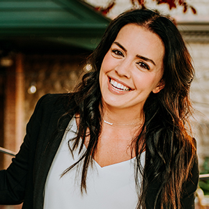 Jen George headshot smiling with white top and black blazer